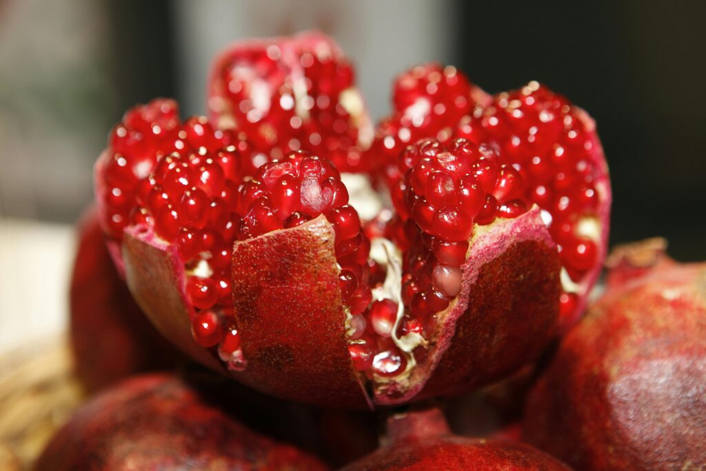pomegranate-open-cores-fruit-fruit-logistica-65256-65256 Detailed macro shot of a fresh, vibrant pomegranate exposing its juicy seeds.